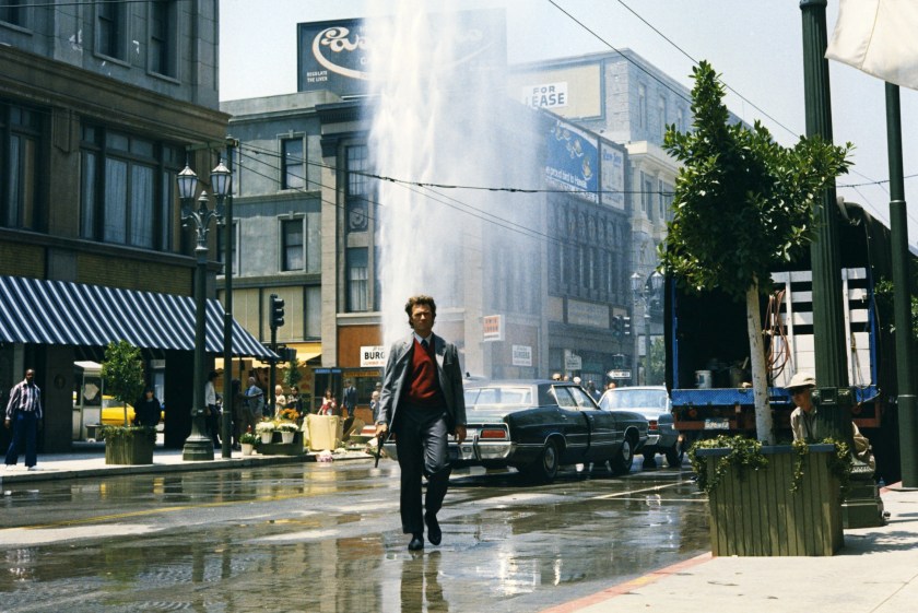 Clint Eastwood, US actor, holding a .44 Magnum handgun, with a broken fire hydrant gushing water into the air behind him, in a publicity still from the film, 'Dirty Harry', USA, 1971. The 1971 thriller, directed by Don Siegel (1912-1991), starred Eastwood as 'Inspector Harry Callahan'. (Photo by Silver Screen Collection/Getty Images)