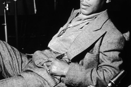 circa 1945:  EXCLUSIVE American jazz saxophonist Johnny Hodges (1907-1970) leans back in a chair with a saxophone resting next to him. Hodges wears a suit and a felt hat.  Other members of the band are seated in the background.  (Photo by Metronome/Getty Images)