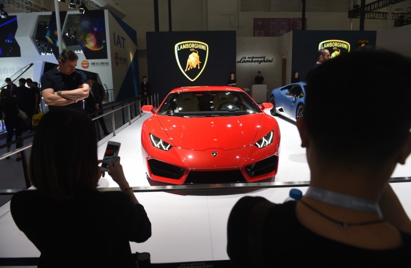 Visitors look at a Lamborghini Huracan LP 580-2 at the Beijing Auto Show in Beijing on April 26, 2016. Global carmakers have gathered in Beijing, to show off their wares as competition intensifies and growth slows in the world's biggest auto market, with the key SUV and new energy vehicle sectors the focus of attention. / AFP / GREG BAKER (Photo credit should read GREG BAKER/AFP/Getty Images)