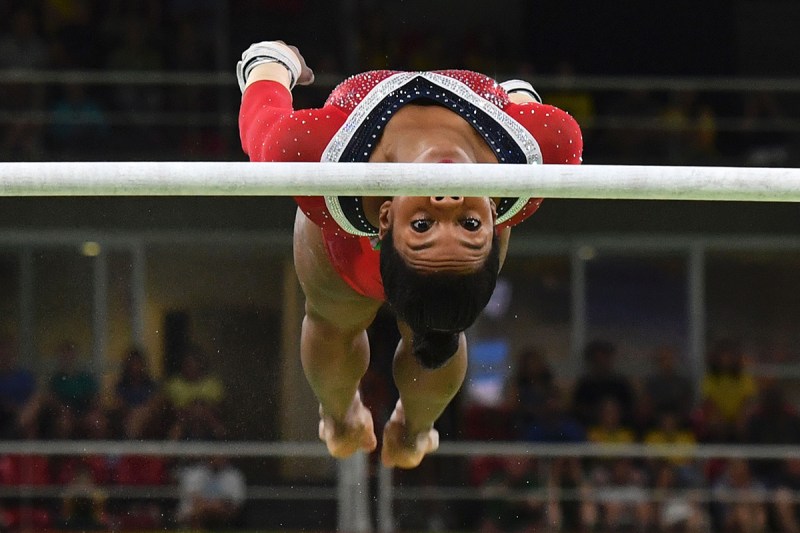 TOPSHOT - US gymnast Gabrielle Douglas competes in the women's uneven bars event final of the Artistic Gymnastics at the Olympic Arena during the Rio 2016 Olympic Games in Rio de Janeiro on August 14, 2016. / AFP / Ben STANSALL (Photo credit should read BEN STANSALL/AFP/Getty Images)