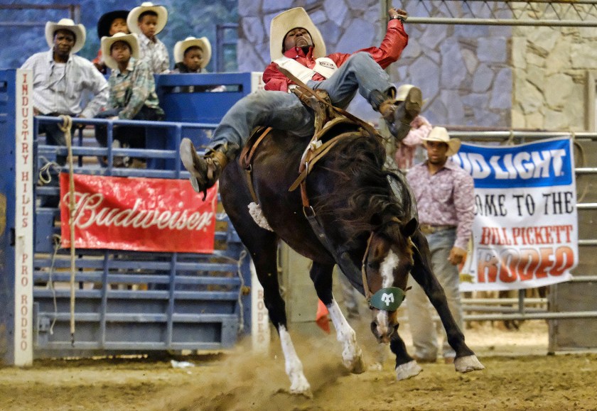 Tre Hosley competes in a bareback riding event at the Bill Pickett Invitational Rodeo in Industry, Calif., on Saturday, June 16, 2016. "Gangsters turn into little kids when they see a horse," says the Compton, Calif. resident, recalling how he once rode one into the wrong neighborhood and was confronted by a handful of gang members who wanted to play with the horse. (AP Photo/Richard Vogel)