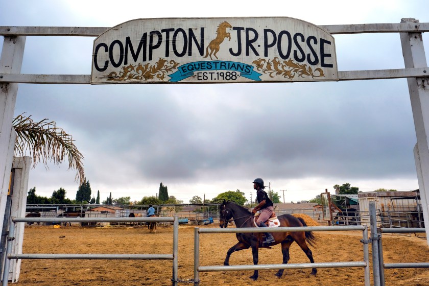 Nathon Bonner warms up one of the horses in the Compton Junior Posse Youth Equestrian Program in Compton, Calif., on Saturday, June 6, 2016. Hundreds of people keep horses in their backyards in its agriculturally-zoned Richland Farms neighborhood and ride them on the streets around town, as well as at rodeos and other equestrian competitions across the country. (AP Photo/Richard Vogel)