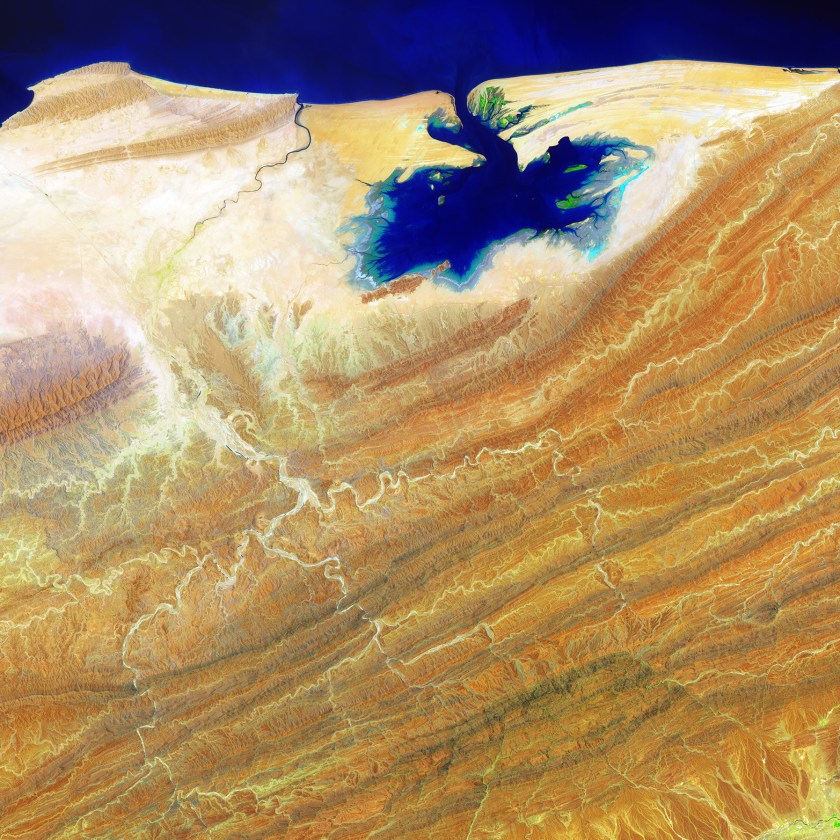 Like blue ink bleeding onto parchment, the Khor Kalmat lagoon branches off the Arabian Sea and spills into the southern Pakistan landscape near the Makran Coast Range. Mudflats cover almost the entire lagoon, which fills with shallow water at high tides. The small areas of green are isolated pockets of mangrove forest. (USGS/NASA)