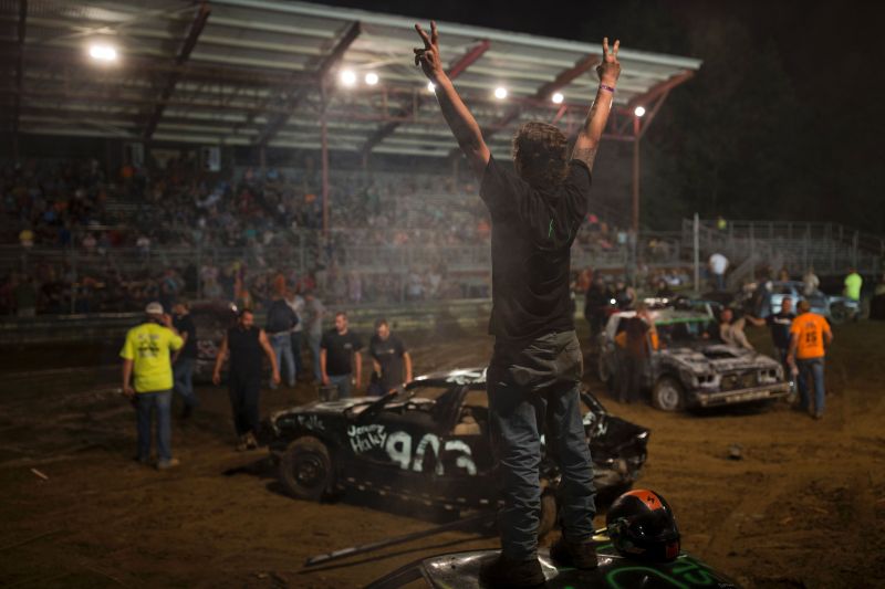 A driver gestures toward the crowd after a heat in the annual demolition derby at the Cambria County Fair on September 8, 2016, in Ebensburg, Pennsylvania. / AFP / DOMINICK REUTER (Photo credit should read DOMINICK REUTER/AFP/Getty Images)