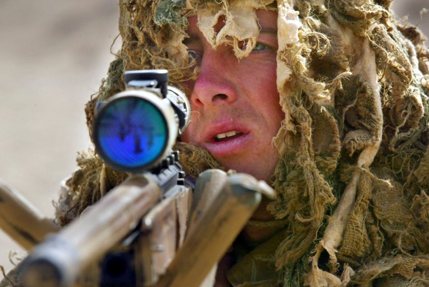 Marine Alasdair Kane, a British Royal Marine soldier from the 42nd Commando Lima Brigade, goes through training exercises in camouflage using a .338 sniper rifle March 10, 2003 in the desert 70 kilometers from Kuwait city near the Iraqi border. (Paula Bronstein/Getty Images)