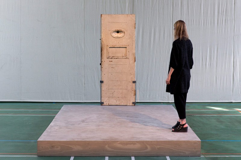 An assistant stands on an artwork by French artist Jean-Michel Pancin which replicates by way of the original door and exact dimensions the prison cell of author Oscar Wilde when he was incarcerated in Reading prison during an exhibition at the prison on September 1, 2016. Reading Prison will open to the public for a major new project in which leading artists, performers and writers respond to the work of the prison's most famous inmate Oscar Wilde. / AFP / JUSTIN TALLIS / RESTRICTED TO EDITORIAL USE - MANDATORY MENTION OF THE ARTIST UPON PUBLICATION - TO ILLUSTRATE THE EVENT AS SPECIFIED IN THE CAPTION (Photo credit should read JUSTIN TALLIS/AFP/Getty Images)