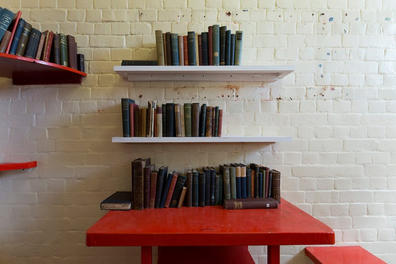 Copies of books by author Oscar Wilde sit on a shelf in a cell at Reading prison during an exhibition at the prison on September 1, 2016 in Reading. Reading Prison will open to the public for a major new project in which leading artists, performers and writers respond to the work of the prison's most famous inmate Oscar Wilde. / AFP / JUSTIN TALLIS (Photo credit should read JUSTIN TALLIS/AFP/Getty Images)