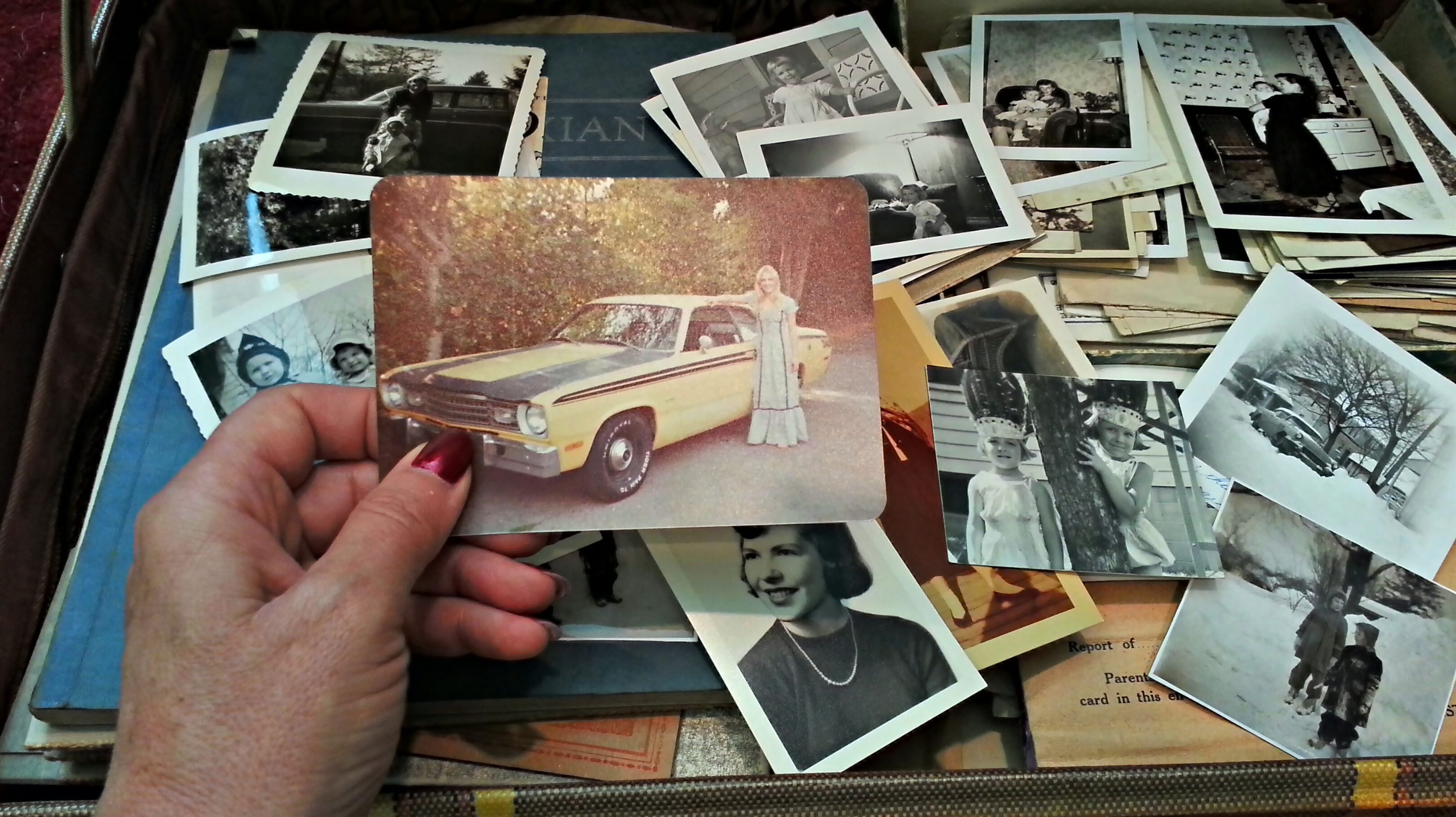 A woman is looking through a trunk of old photos.  (Getty Images)