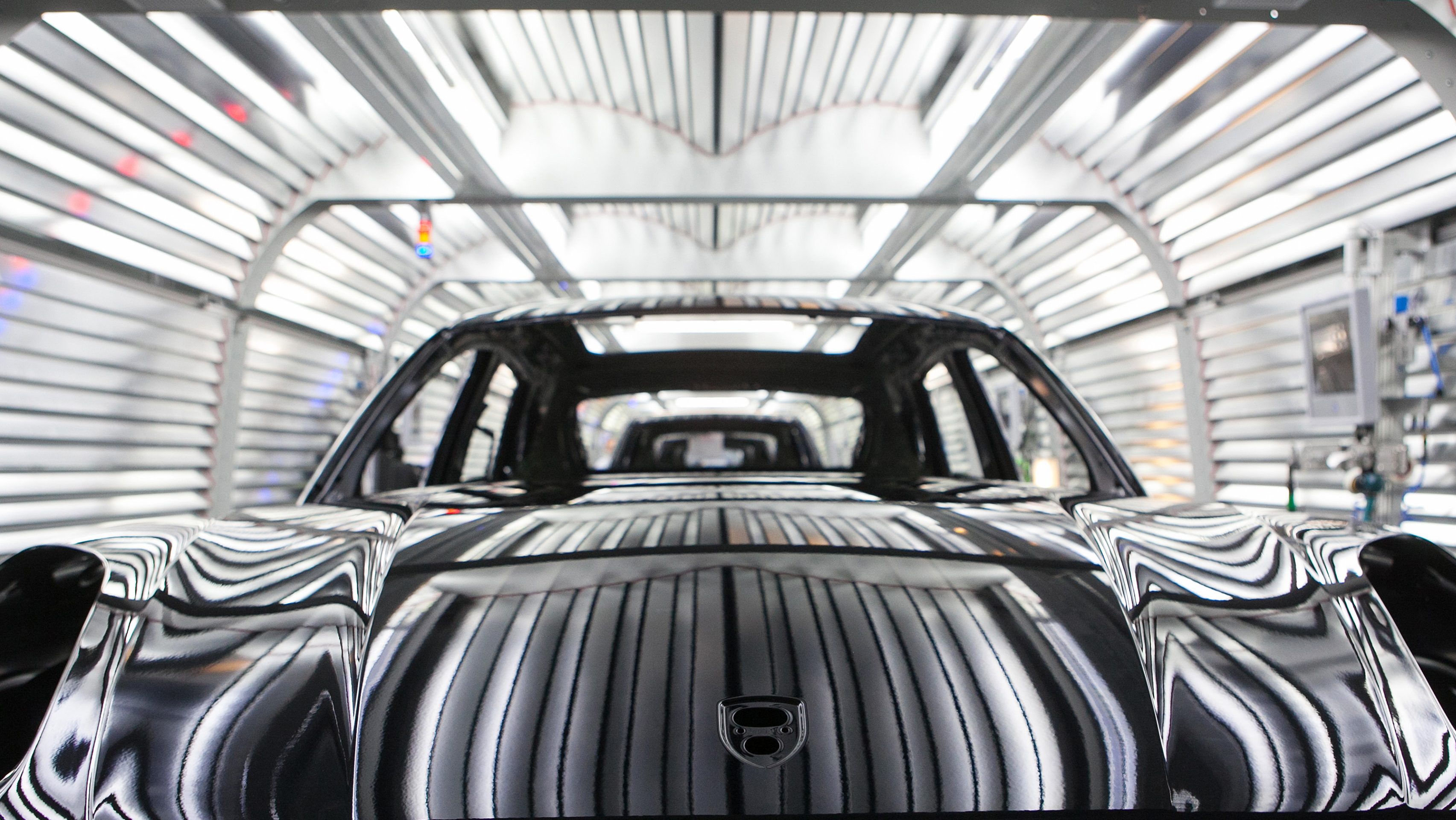 Painted chassis of Porsche Macan sport-utility vehicles (SUV) pass through the paint shop inside the newly expanded Porsche AG factory in Leipzig, Germany, on Wednesday, Feb. 5, 2014. Porsche AG Chief Executive Officer Matthias Mueller said the high-end automaker will exceed 200,000 in annual deliveries in 2015, three years earlier than first targeted, on demand for the Macan compact sport-utility vehicle going on sale later this year. (Krisztian Bocsi/Bloomberg via Getty Images)