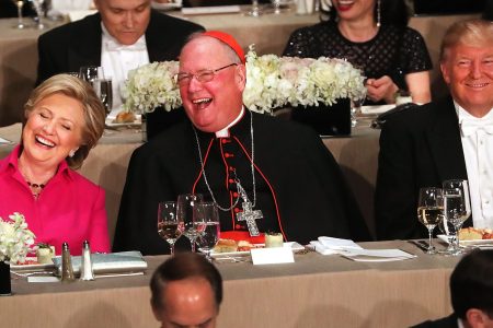 Cardinal Timothy Dolan sits between, Hillary Clinton and Donald Trump attend the annual Alfred E. Smith Memorial Foundation Dinner at the Waldorf Astoria on October 20, 2016 in New York City.The white-tie dinner, which benefits Catholic charities and celebrates former Governor of New York  Al Smith, has been attended by presidential candidates since 1960 and gives the candidates an opportunity to poke fun at themselves and each other.  (Spencer Platt/Getty Images)