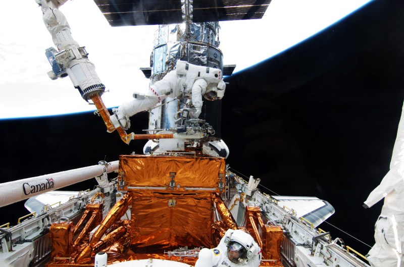 In this handout from NASA, STS-125 mission specialists astronaut Michael Good (L) and astronaut Mike Massimino participate in the mission's fourth spacewalk to repair the Hubble Space Telescope (NASA via Getty Images)