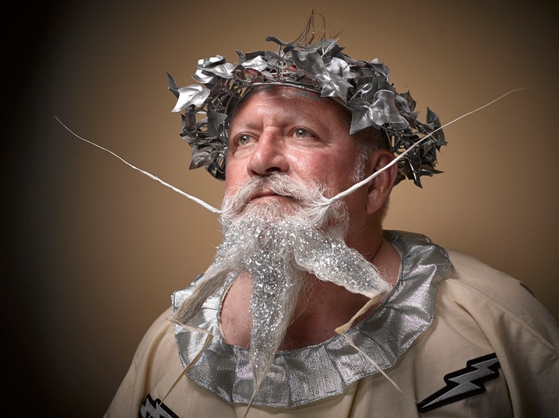 PIC BY GREG ANDERSON / CATERS NEWS - (PICTURED: A contestant of the beard championship with a god like theme.) - Gents from around the world descended on Nashville earlier this month fighting for the title of best beard in the National Beard and Moustache Championship. The annual competition covers 17 categories in which the men can compete, ranging from freestyle, to natural, to facial hair inspired by icons such as Dali and the Musketeers. With the competition as stiff as the waxed moustaches, competitors had to go beard to beard to decide whose facial fuzz was the most fan-TASH-tic. Competitors were judged on their overall appearance, style and personality, with judges also considering originality and creativity in the freestyle categories. Contestants certainly rose to the challenge with perfectly curled beards and also more outrageous statement styles, such as a Tim Burton themed beard, and a beard styled to look like a beak. - SEE CATERS COPY