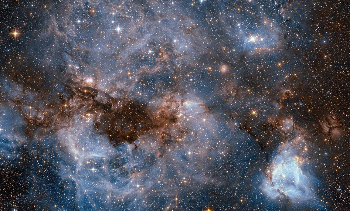 This shot from the NASA/ESA Hubble Space Telescope shows a maelstrom of glowing gas and dark dust within one of the Milky Way’s satellite galaxies, the Large Magellanic Cloud (LMC). This stormy scene shows a stellar nursery known as N159, an HII region over 150 light-years across. N159 contains many hot young stars. These stars are emitting intense ultraviolet light, which causes nearby hydrogen gas to glow, and torrential stellar winds, which are carving out ridges, arcs, and filaments from the surrounding material. At the heart of this cosmic cloud lies the Papillon Nebula, a butterfly-shaped region of nebulosity. This small, dense object is classified as a High-Excitation Blob, and is thought to be tightly linked to the early stages of massive star formation. N159 is located over 160 000 light-years away. It resides just south of the Tarantula Nebula (heic1402), another massive star-forming complex within the LMC. It was previously imaged by Hubble’s Wide Field Planetary Camera 2, which also resolved the Papillon Nebula for the first time.