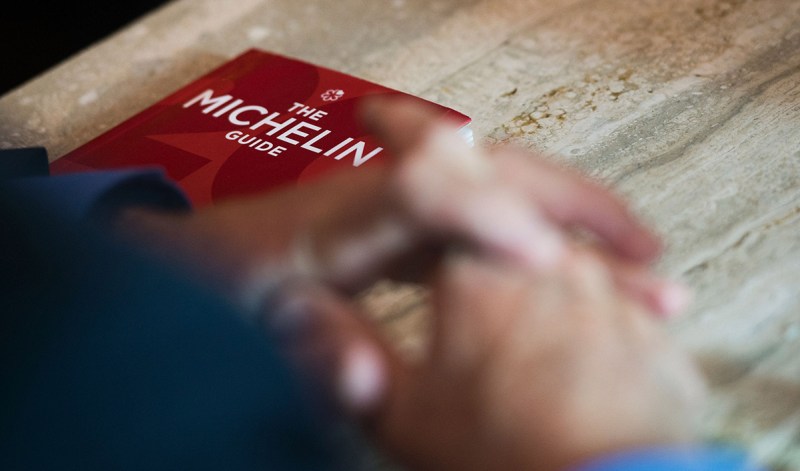 Michael Ellis from Michelin poses with the Michelin guide book at a restaurant in Washington, DC on October 12, 2016. The Michelin Guide unveiled its first edition for the US capital Washington on Thursday, awarding coveted stars to a dozen restaurants it said were part of a hot foodie scene. Alas, no restaurant got the full blessing of three stars, although three received two stars and nine got one. / AFP / Andrew CABALLERO-REYNOLDS / TO GO WITH AFP STORY BY ELODIE CUZIN- "Michelin unveils Washington guide, no three-star eateries" (Photo credit should read ANDREW CABALLERO-REYNOLDS/AFP/Getty Images)