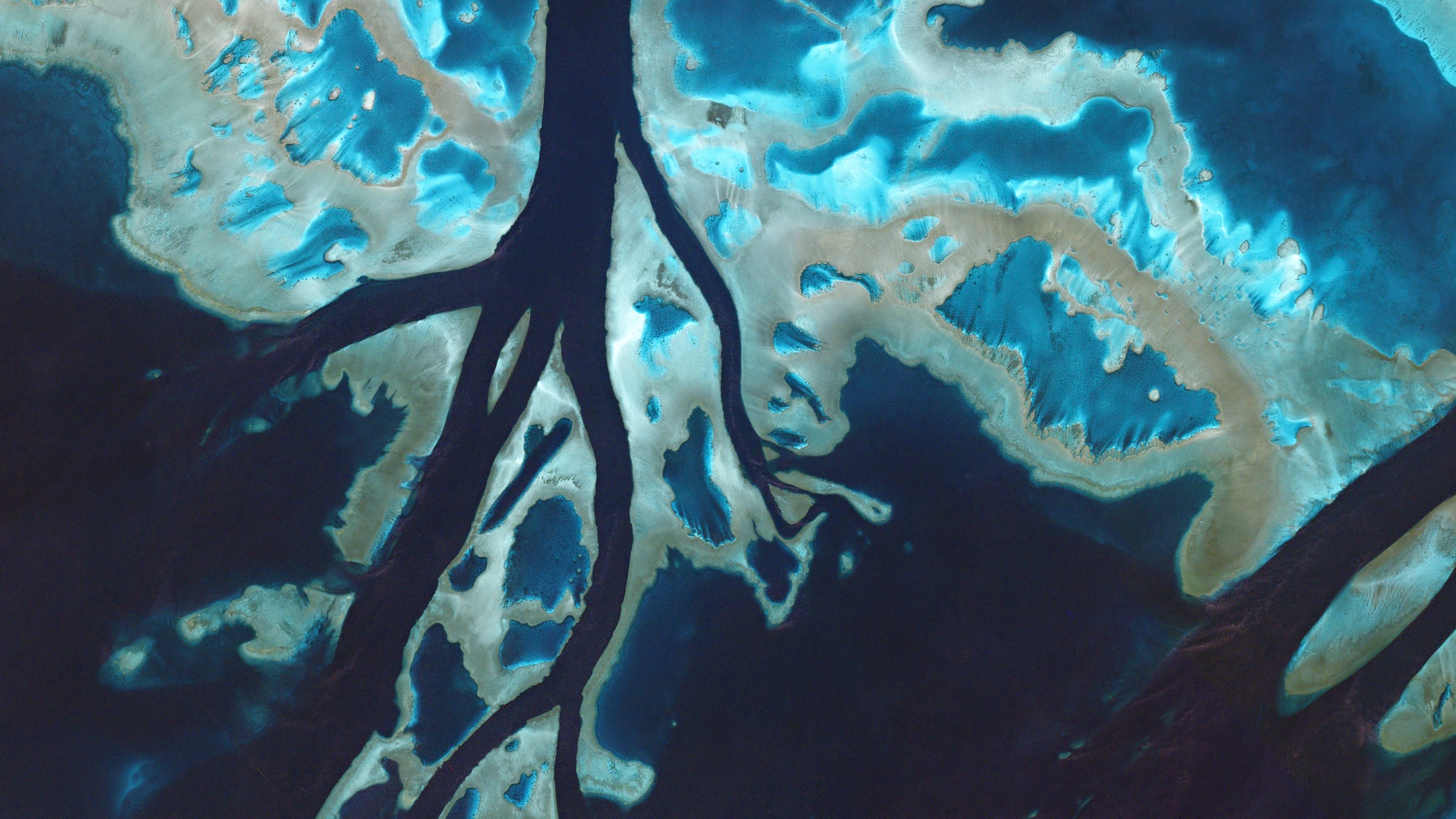 Taken on July 7, 2016, tidal channels cut through unnamed reefs off the coast of Queensland. These corals are part of the enormous Great Barrier Reef, which stretches for 1,400 miles along the coast of mainland Australia in the Coral Sea. (Courtesy Planet Labs)