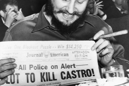 (Original Caption) Seems amused by assassination plot...Seeming quite amused, Cuban Prime Minister Fidel Castro holds up a newspaper headlining the discovery of a plot to kill Castro here, April 23rd. Castro was at the Overseas Press Club at the time. Police said five brothers had been sent here from Philadelphia, Pa., to assassinate the bearded leader. Police said that three other men, including a sixth brother, were believed to be in New York in connection with the plot to kill Castro. Earlier in the day, when asked about a reported assassination attempt, Castro had replied, "In Cuba, they had tanks, planes and they run away. So what are they going to do here? I sleep well and don't worry at all." (Bettmann/Contributor/Getty Images)