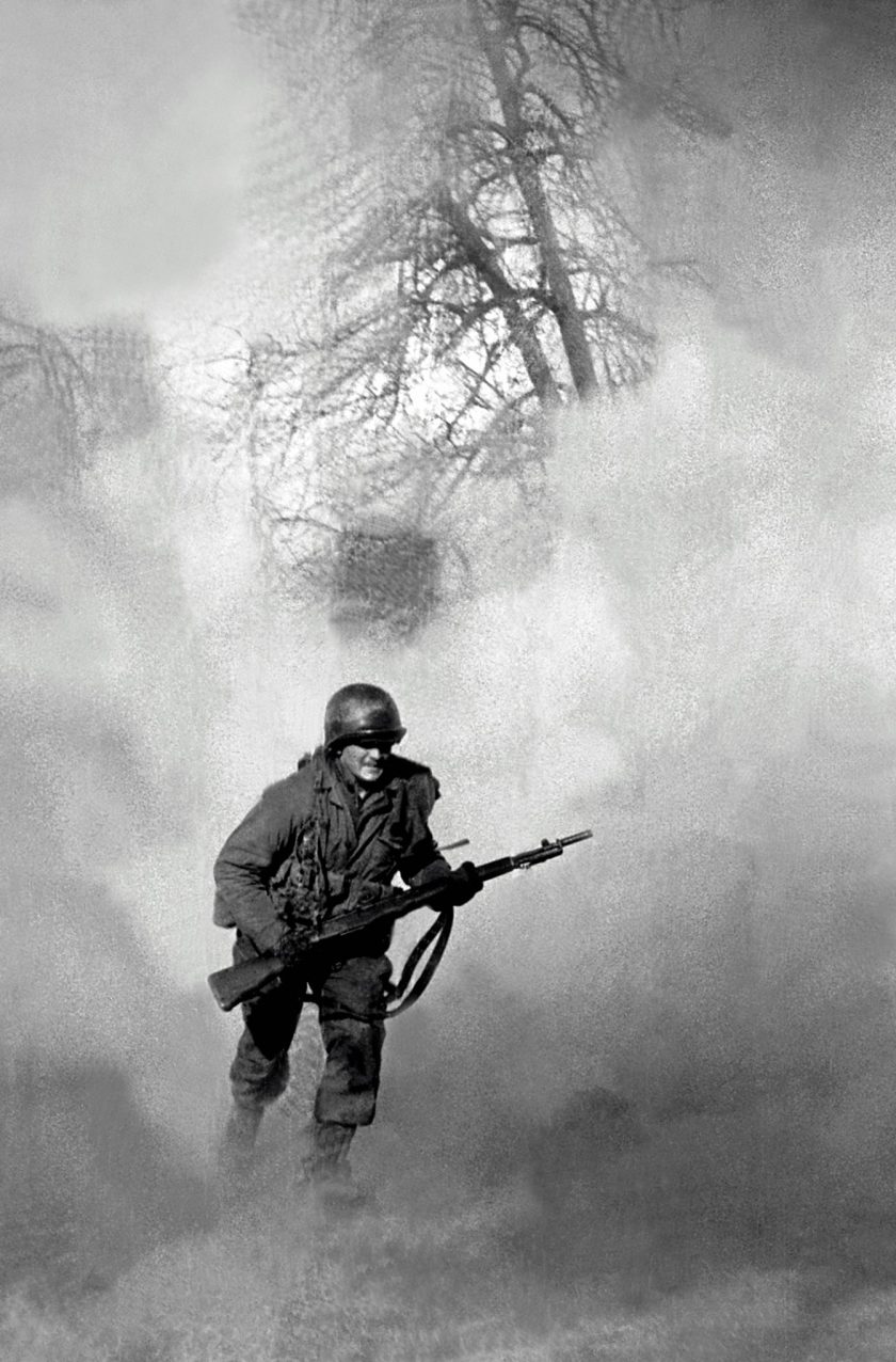 American GI Ivan Parrott is seen running through smoke in no mans land near Neuss, Germany during the Battle for the Rhine, World War II, 1st March 1945. (Tony Vaccaro/Getty Images)