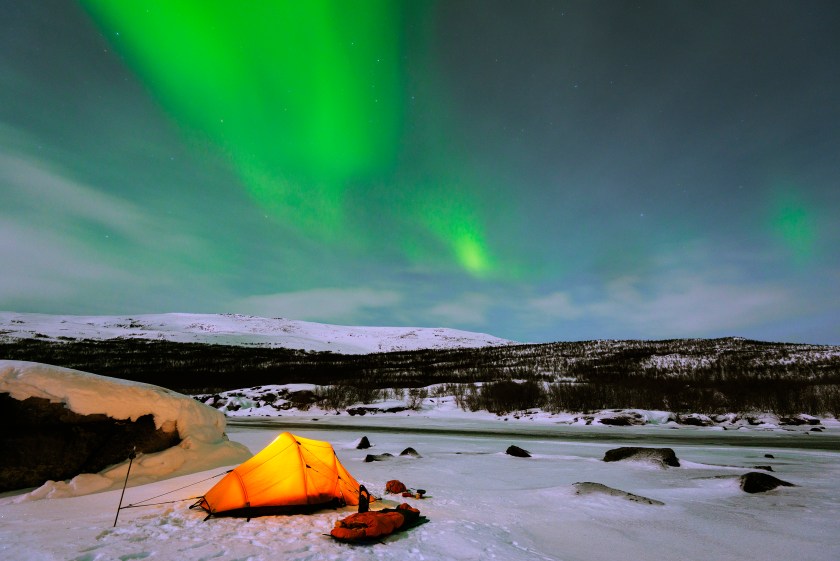 Winter campers soaking up the aurora borealis on the Kungsleden hiking trail in Finland's National Park outside Helsinki (Getty Images)