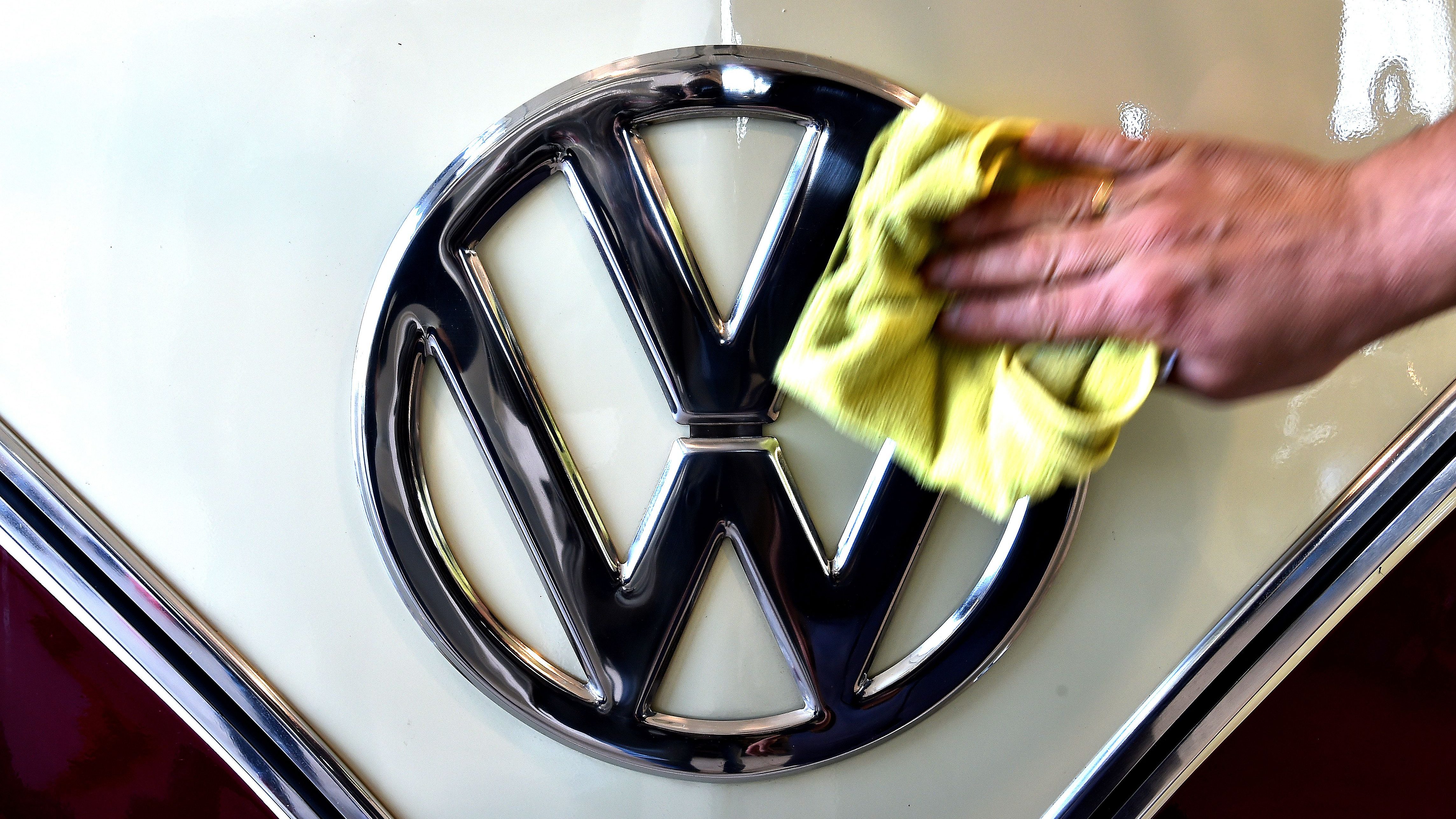 A man cleans the VW logo on a vintage Volkswagen Kombi bus (van, transporter or camper) restored by the "T1 specialist" team, on November 3, 2016 at the garage Nucci in Florence. (Alberto Pizzoli/AFP/Getty Images)