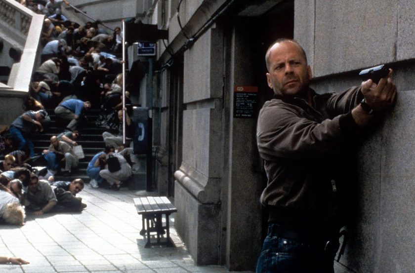 Bruce Willis aims a gun as others duck for cover in a scene from the film 'Mercury Rising,' 1998. (Universal/Getty Images)