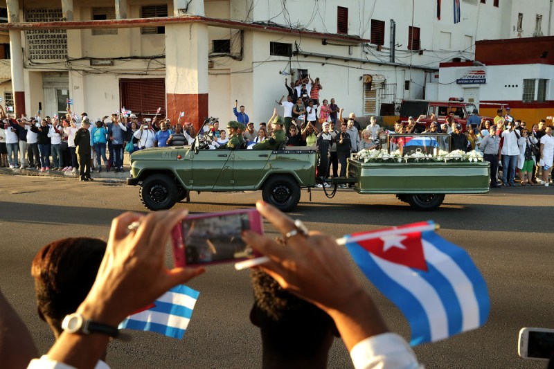 A military truck pulls a trailer with the flag-draped chest that holds the remains of former President Fidel Castro as thousands of Cubans line the famous Malecon seaside boulevard to pay their respects (Chip Somodevilla/Getty Images)