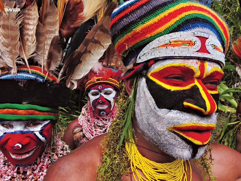 Dancers decorated with colored clay preparing for a “sing sing” - a cultural festival in which different tribes come together to celebrate and tell stories and legends of their ancestors by dancing, chanting and performing courting rituals. (Courtesy National Geographic Traveler)