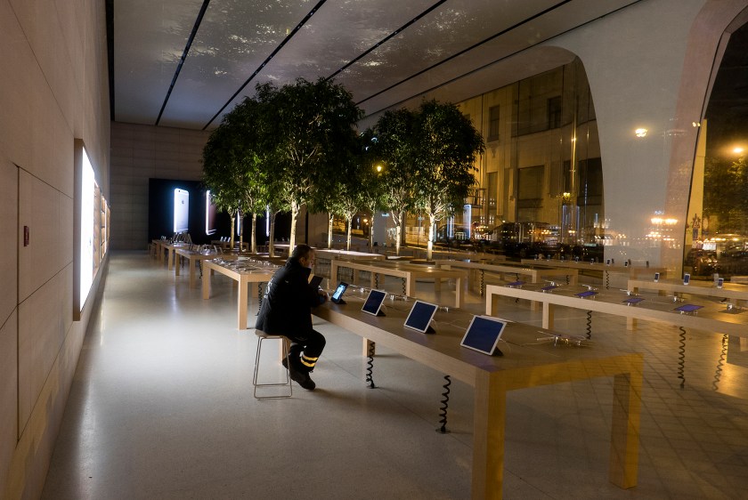 A security officer on duty is looking at Apple product in the Brussels Apple store at night. (Thierry Tronnel/Corbis via Getty Images)