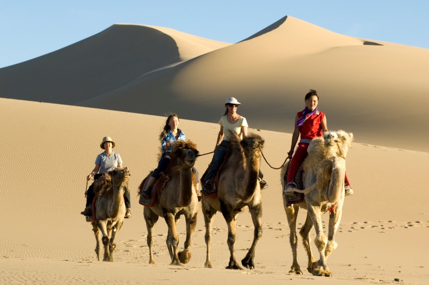 A family rides with a Mongolian guide through the Khongoryn Els sand dunes. The dunes are the most famous feature of Gobi Gurvansaikhan National Park in Mongolia. (Getty Images)