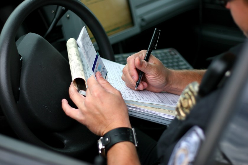 A police officer writes a traffic ticket. (Getty Images)