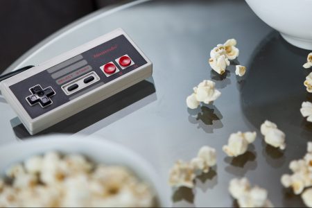 A vintage Nintendo NES controller photographed on a glass table, surrounded by bowls of snacks, taken on July 9, 2013. (Philip Sowels/Future Publishing via Getty Images)