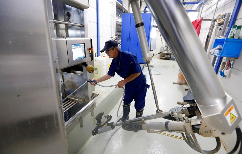 An employee sprays water into a DeLaval Inc. voluntary milking system at a dairy farm operated by Kalm Kakuyama K.K. in Ebetsu, Hokkaido, Japan, on Tuesday, Sept. 6, 2016. On the northern island of Hokkaido, Japan's top dairy-producing region, Jin Kawaguchiya transformed the 20-cow farm he inherited from his father-in-law 16 years ago into Asia's largest automated milking factory. Robots extract milk from 360 cows three times a day and make sure the animals are fed and healthy. (Tomohiro Ohsumi/Bloomberg via Getty Images