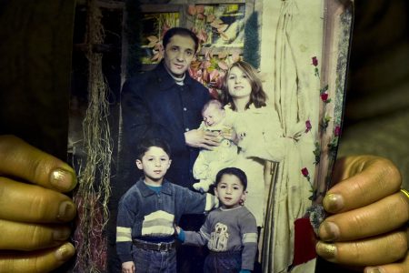 In this Thursday, Jan. 19, 2017 photo, Fidan Kiru, 31, a Syrian refugee from Afrin, holds a photograph taken in 2004 showing herself and her husband Mohyeddin, when he was 27-year-old, and her sons, younger to older, Avindar, 8 months, Khalid, 4 and Levant, 6, at her tent in Kalochori refugee camp on the outskirts of the northern Greek city of Thessaloniki. "This is the only group family picture we have, my husband is currently in Germany and I hope they will allow me to join him." Fidan said. (AP Photo/Muhammed Muheisen)