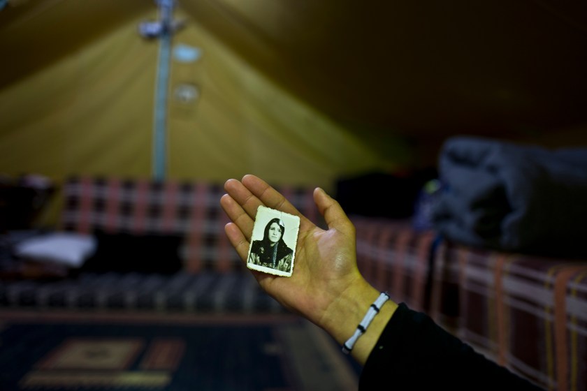 In this Tuesday, Jan. 17, 2017 photo, Kulnawaz Youssef, 13, a Syrian refugee from Al-Qamishly, shows a photograph of her mother Suad, at her tent in Kalochori refugee camp on the outskirts of the northern Greek city of Thessaloniki. "We fled our home with nothing, having my mother's photograph with me makes me feel safe." Kulnawaz said. (AP Photo/Muhammed Muheisen)