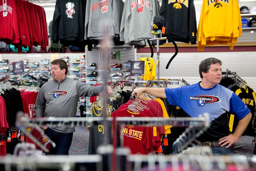 Brothers Todd, right, and Scott Yeomans, owners of a custom sportswear company, stand in their store in Prairie du Chien, Wis., Friday, Jan. 20, 2017. They said they're trying to do the right thing by making their products with American-made fabrics and American labor, but they're competing against companies that use factories overseas. They'd like to provide health insurance, but they've run the numbers and it would cost $200,000 a year, far more than they can spend. Recently, a longtime worker left for a job with benefits. (AP Photo/David Goldman)