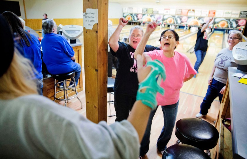 Jackie Suelflow, right, and Mikey Clanton, left, dance and sing during a ladies bowling night in Prairie du Chien, Wis., Wednesday, Jan. 18, 2017. Here in Crawford County, residents often recite two facts about their hometown, the first one proudly: It is the second-oldest community in the state. The next is that it's also one of the poorest. There are no rusted-out manufacturing plants to embody this discontent. The downtown main street bustles with tourists come summer. Just a few vacant storefronts hint at the seething resentment that life still seems harder here than it should. (AP Photo/David Goldman)