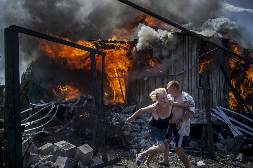 Long-Term Projects - First Prize: Civilians escape from a fire at a house destroyed by the air attack in the Luhanskaya village. (Valery Melnikov for Rossiya Segodnya)