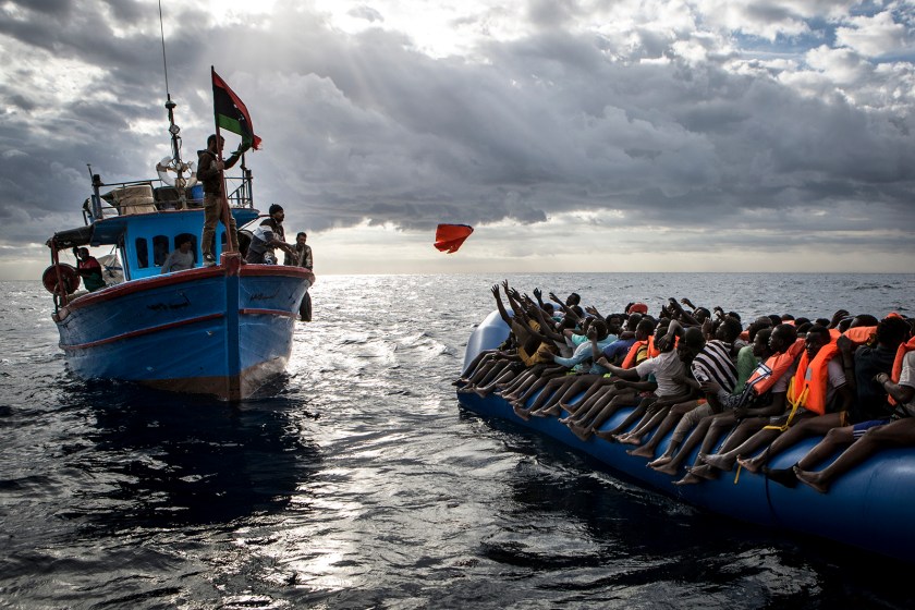 Spot News - Third Prize, Stories: Libyan fishermen throw a life jacket at a rubber boat full of migrants. Migrants are very often not given any life jackets or means of communication by their smugglers. More often than not they only have some water, food and not enough fuel to make it to Italy. The central Mediterranean migration route, between the coasts of Libya and Italy, remains busy. According to reports by the UNHCR, 5,000 people died while attempting to cross the Mediterranean in 2016. (Mathieu Willcocks)