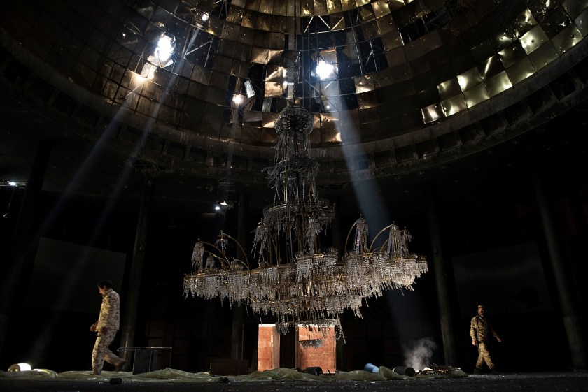 General News - Third Prize, Stories: Fighters of the Libyan forces affiliated to the Tripoli government walk around the gigantic chandelier of the conference room in Ouagadougou Congress Complex. Sirte, Libya, is one of the three self-proclaimed capitals of the so-called Islamic State, along with Raqqa in Syria and Mosul in Iraq. It was the first of the three to fall, with an offensive launched by the Libyan government in May 2016. It took seven months of fighting, 500 American airstrikes, the lives of 700 Libyan soldiers and more than 3,000 injured Libyan soldiers to finally declare the city free. (Alessio Romenzi)