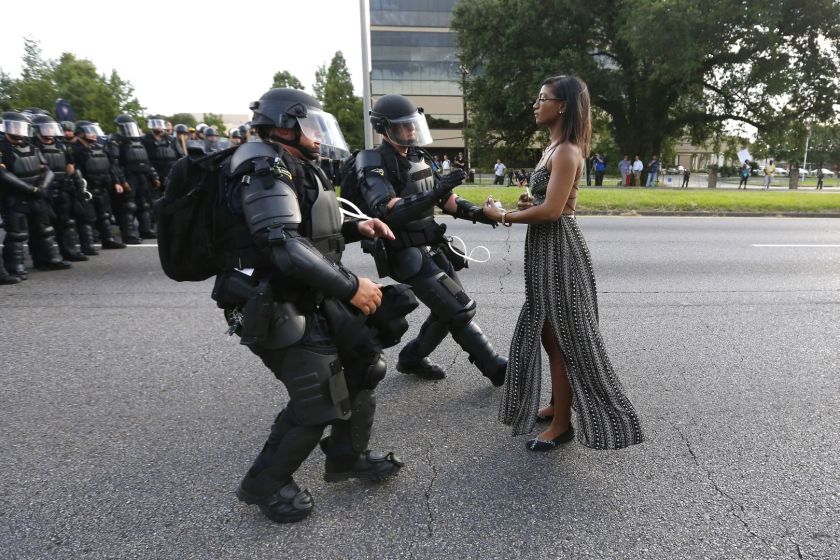 Contemporary Issues - First Prize, Singles: Lone activist Ieshia Evans stands her ground while offering her hands for arrest as she is charged by riot police during a protest against police brutality outside the Baton Rouge Police Department in Louisiana, USA, on 9 July 2016. Evans, a 28-year-old Pennsylvania nurse and mother of one, traveled to Baton Rouge to protest against the shooting of Alton Sterling. Sterling was a 37-year-old black man and father of five, who was shot at close range by two white police officers. The shooting, captured on a multitude of cell phone videos, aggravated the unrest coursing through the United States in previous years over the use of excessive force by police, particularly against black men. (Jonathan Bachman/Thomson Reuters)