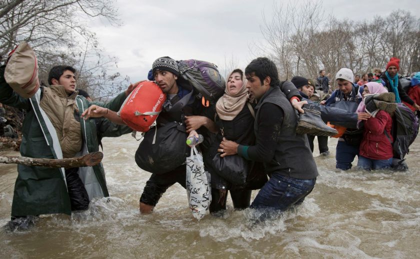 Contemporary Issues - Second Prize, Singles: A woman is supported by two men while crossing a river, as refugees attempt to reach Macedonia on a route that would bypass the border fence, on 14 March 2016. Hundreds of refugees walked out of an overcrowded camp on the Greek-Macedonian border on this day, shortly after the closure of Macedonia's borders, determined to head north despite the dangers of the crossing. (Vadim Ghirda/The Associated Press)