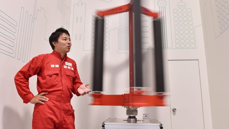 This picture taken on October 20, 2016 shows engineer Atsushi Shimizu, founder and CEO of the Japanese venture company Challenergy, standing next to his bladeless wind turbine in Tokyo. The amount of electricity produced by wind nearly doubled in 2016 from a year earlier, according to a recent survey by the Japan Wind Power Association. But wind power's share of Japan's total energy mix is still less than one percent. / AFP PHOTO / Kazuhiro NOGI / TO GO WITH Japan-energy-environment,FOCUS by Harumi Ozawa (Photo credit should read KAZUHIRO NOGI/AFP/Getty Images)