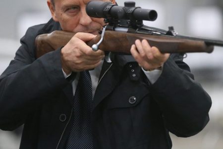 Russian Federal Security Service (FSB) Chief Alexander Bortnikov holds a gun-machine while visiting the Kalashnikov concern (Mikhail Svetlov/Getty Images)