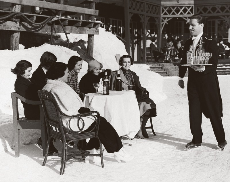 An ice-skating waiter in St. Moritz, Switzerland, delivers gin and soda to British ladies, 1920s (Hulton-Deutsch Collection/CORBIS/Corbis via Getty Images)