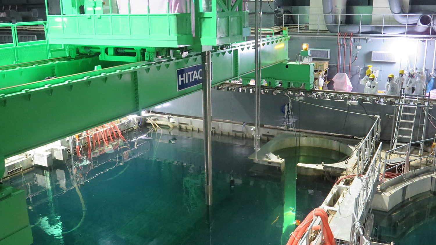 In this handout image provided by Tokyo Electric Power Co, workers remove nuclear fuel rods from a pool at No. 4 reactor of the Fukushima Daiichi Nuclear Power Plant on November 18, 2013 in Okuma, Fukushima, Japan.  TEPCO started removing nuclear fuel from a damaged reactor building for the first time, marking a new stage in the decades-long decommissioning process. The operation to empty the storage pool in the No. 4 reactor building, which holds 1,533 nuclear fuel assemblies, began and expected to be removed by December 2014. But the overall decommissioning work at the stricken nuclear plant is expected to take 30 to 40 years to complete.  (Tokyo Electric Power Co via Getty Images)