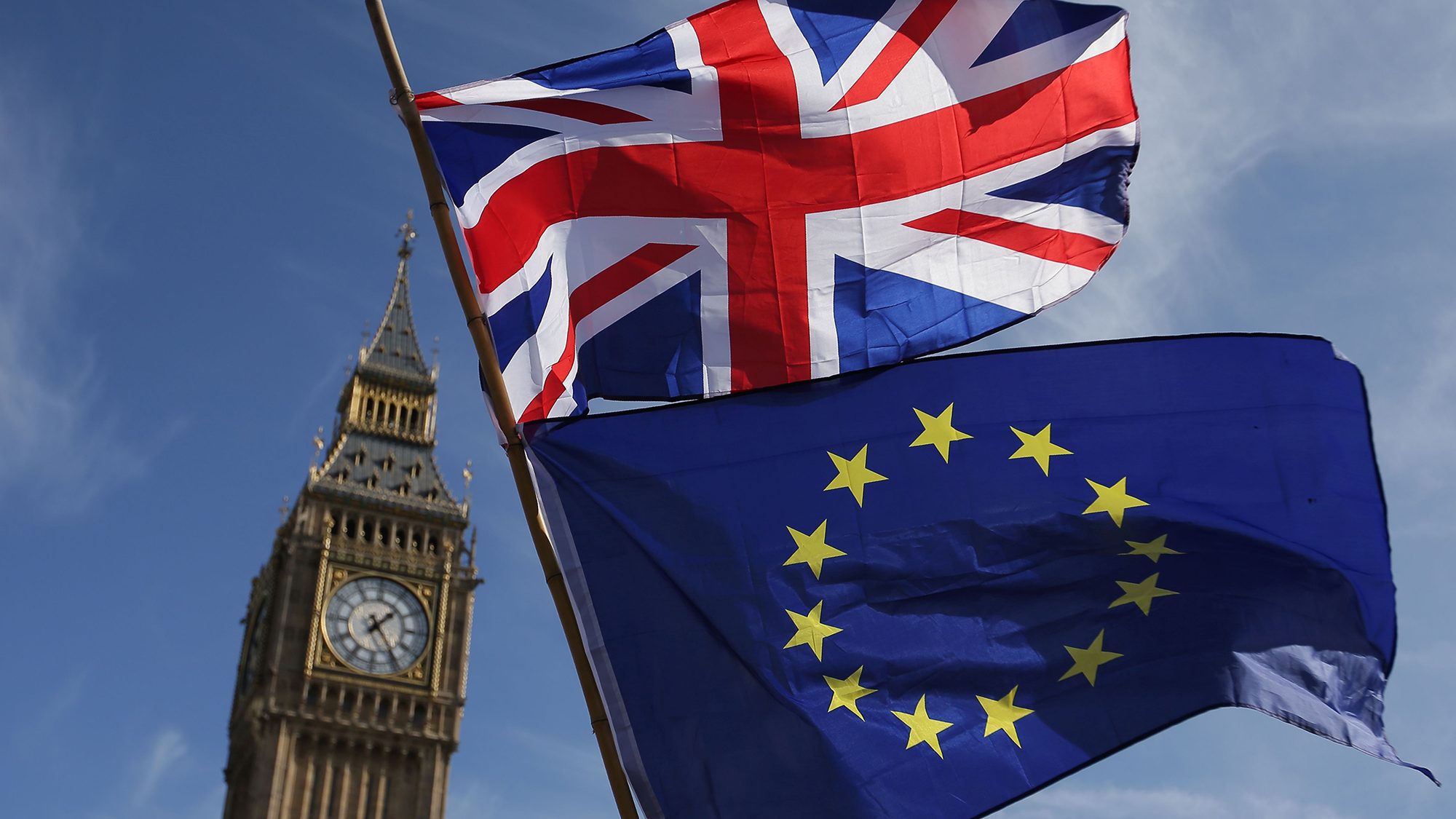 An EU flag and a Union flag held by a demonstrator is seen with Elizabeth Tower (Big Ben) and the Houses of Parliament as marchers taking part in an anti-Brexit, pro-European Union (EU) enter Parliament Square in central London on March 25, 2017, ahead of the British government's planned triggering of Article 50. (Daniel Leal-Olivas/AFP/Getty Images)