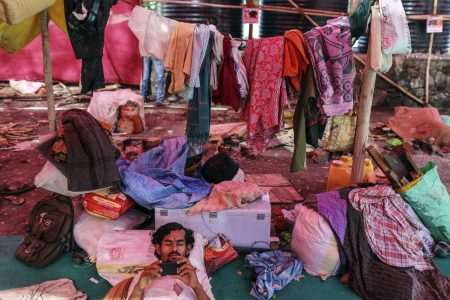 A man watches a film on a smartphone inside a temporary suburban camp, set up by local political party Shiv Sena for the rural poor traveling to Mumbai to find water, in Thane, Maharashtra, India, on Sunday, April 17, 2016. (Dhiraj Singh/Bloomberg via Getty Images)