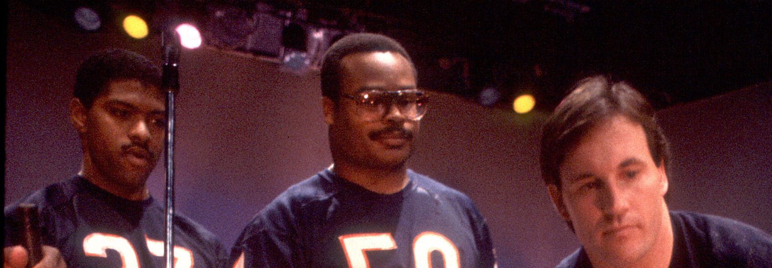 Mike Richardson (left), Hall of Fame linebacker Mike Singletary (center), and Gary Fencik (right) of the Chicago Bears get instruction from Dick Meyer during filming of "The Super Bowl Shuffle" in Chicago in 1985. (Paul Natkin/Getty Images)