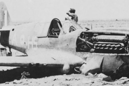 A German soldier near a crashed Curtiss Kittyhawk fighter in North Africa. (Wikipedia)