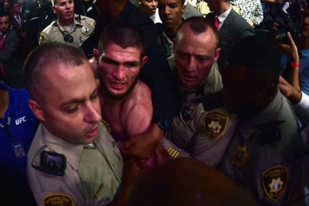 After defeating Conor McGregor at UFC 229, Khabib Nurmagomedov is escorted by Las Vegas police from the T-Mobile Arena after a post-fight melee that involved numerous scuffles inside and outside the octagon. (Photo credit: Harry How/Getty Images)