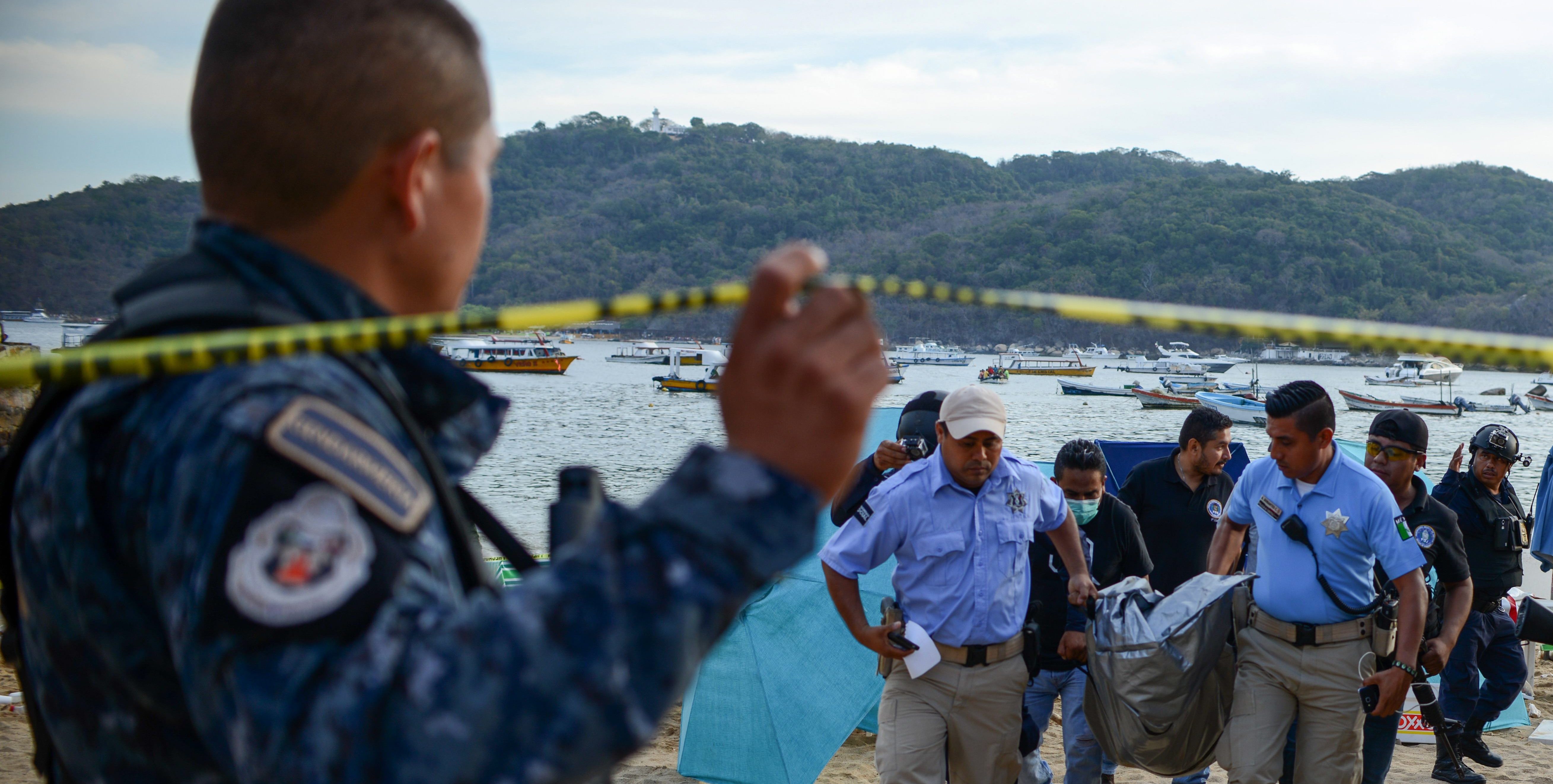 Forensic personnel and police officers carry the body of a murdered man, at Caletilla beach, in the touristic city of Acapulco, Guerrero State, Mexico, on March 18, 2018.
Guerrero is one of Mexico's poorest and most violent states, where a lucrative drug trade has flourished. (FRANCISCO ROBLES/AFP/Getty Images)